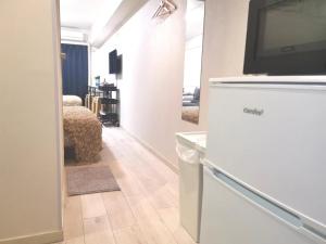 a living room with a tv on top of a refrigerator at House L in Shinjuku in Tokyo +40 photos
