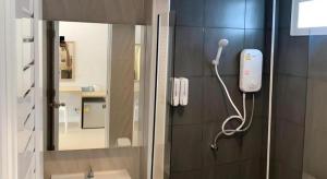 a bathroom with a mirror and a phone on the wall at Thong Prachok Hotel in Sakon Nakhon +89 photos