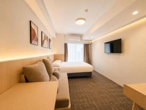 a hotel room with a couch and a bed at Hotel Arashi Nippombashi 1 No006 in Osaka