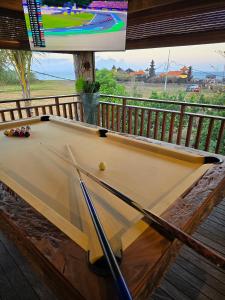 a pool table sitting on a deck with a tv at Beachview Villa near Sanur, Live Sports AFL NRL in Ketewel