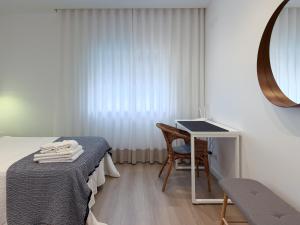 a bedroom with a bed and a table with a mirror at Dani's House - Nazaré in Nazaré