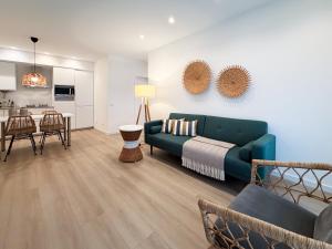 a living room with a blue couch and a kitchen at Dani's House - Nazaré in Nazaré