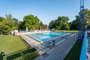 a large swimming pool in a park with a yard at Hiška Radolca - Camping Radovljica in Radovljica