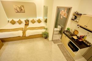 a small room with two beds and a bathroom at Maison Boutique Hotel - Bình An in Phước Lộc Xã