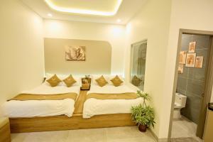 a bedroom with a bed with pillows on it at Maison Boutique Hotel - Bình An in Phước Lộc Xã