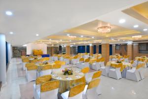 a banquet hall with white tables and yellow chairs at Ginger Jammu , Bari Bramhana in Jammu