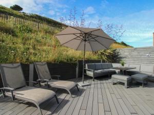 a patio with a table and chairs and an umbrella at 7 Beachdown in Kingsbridge