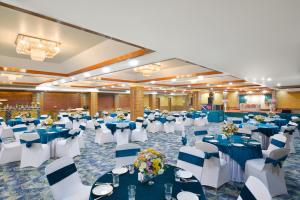 a banquet hall with blue and white tables and chairs at Ginger Jammu , Bari Bramhana in Jammu