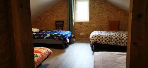 a attic room with two beds and a window at La ferme du lac Saint Front in Saint-Front