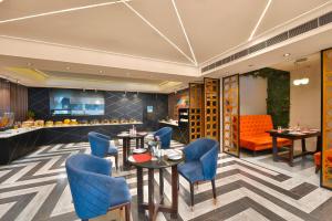 a restaurant with blue chairs and tables and a bar at Ginger Jammu , Bari Bramhana in Jammu
