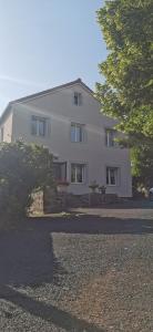 a large white house with trees in front of it at La ferme du lac Saint Front in Saint-Front