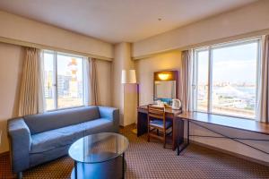 a living room with a couch and a desk with a desk at Kobe Port Tower Hotel in Kobe