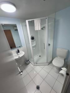 a bathroom with a shower and a toilet and a sink at ASURE Centrepoint Motel in Christchurch