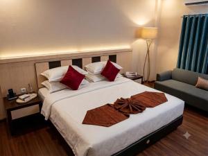a hotel room with a large bed and a couch at Grand Duta Hotel in Palu