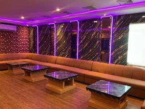 a room with a couch and tables and purple lights at Grand Duta Hotel in Palu