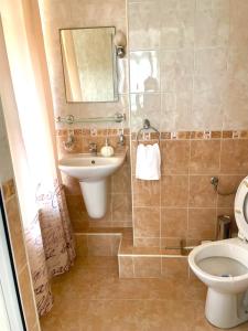 a bathroom with a sink and a toilet and a mirror at Guest House Fanari in Sozopol +51 photos