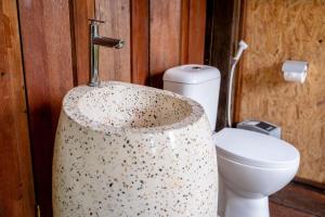 a bathroom with a toilet and a sink at Kalpa House Sidemen in Sidemen