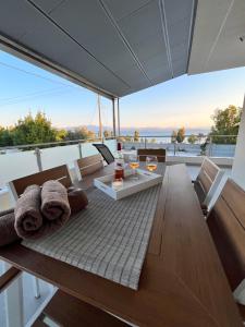a dining table and chairs on the balcony of a house at AMORÉA Jacuzzi Suites Evia in Eretria