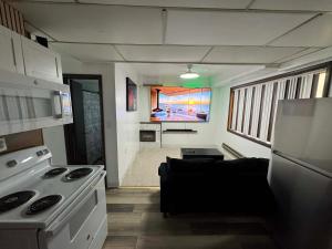 a kitchen and living room with a couch and a tv at Anchorage Fireoved Home Theater Experience in Anchorage
