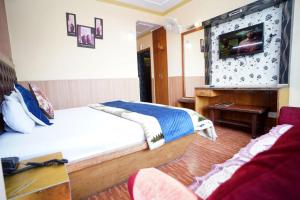 a hotel room with a bed and a tv at Hotel King Palace in Shimla