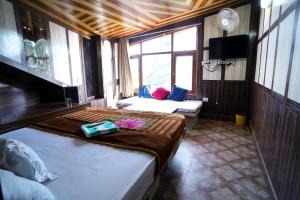 a room with two beds and a tv and a couch at Hotel King Palace in Shimla