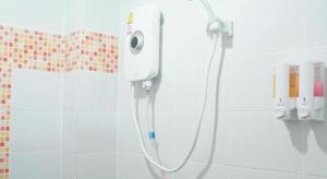 a shower in a bathroom with a hose attached to the wall at Nan Treasure Hotel in Ban Hua Wiang Nua +93 photos