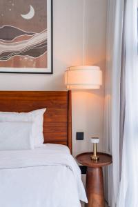 a bedroom with a bed and a table with a lamp at Modern 1BR with Spacious Living Room in Uluwatu