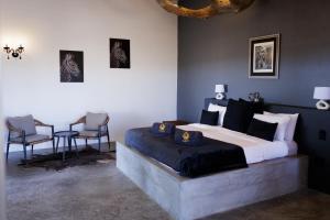 a bedroom with a large bed and two chairs at 3 ALOES GUESTHOUSE in Uis
