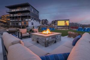 a patio with a fire pit with chairs and a screen at Firefly Lodge - Pool, Theatre, Dog Friendly! in Pigeon Forge