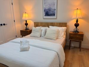 a bedroom with a large white bed with two lamps at Guest Suite in Mission in Mission
