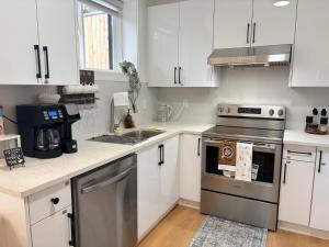 a kitchen with white cabinets and stainless steel appliances at Guest Suite in Mission in Mission