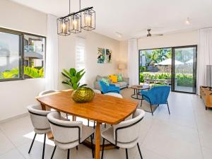 a dining room and living room with a table and chairs at SALTA apartment l Complex Ocean terraces in Poste Lafayette