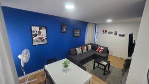 a living room with a couch and a blue wall at Totteham stadium in London
