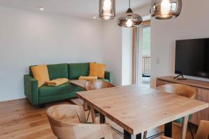 a living room with a green couch and a table at Frankenfelsberg in Oedrotte