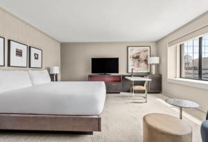 a bedroom with a large white bed and a tv at Grand Hyatt Denver in Denver