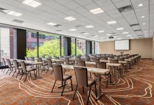 a conference room with tables and chairs and a screen at Grand Hyatt Denver in Denver +86 photos