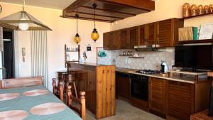 a kitchen with wooden cabinets and a stove top oven at Flowers & garden apartment con vista lago in Manerba del Garda