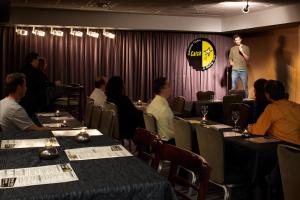a man standing on a stage in a room with people sitting at tables at Hyatt Regency Princeton in Princeton
