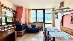 a room with a table and a couch and a television at Flowers & garden apartment con vista lago in Manerba del Garda
