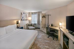 a hotel room with a bed and a desk with a computer at Comfort Inn Sydney - Cape Breton in Sydney