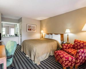 a hotel room with a bed and a chair at Quality Inn At the Mall - Valdosta in Valdosta