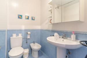 a blue and white bathroom with a toilet and a sink at Apartment Mountain View Torrox town in Torrox +24 photos