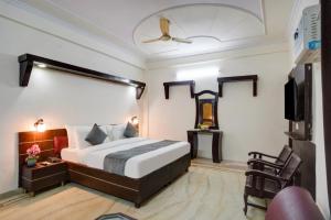 a bedroom with a bed and a flat screen tv at Hotel PP Tower - Near Ghaziabad Railway Station in Ghaziabad +22 photos