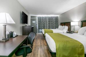 a hotel room with two beds and a desk at Rodeway Inn Kingston Springs in Kingston Springs