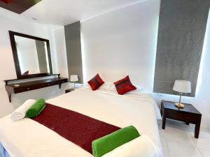 a white bedroom with two beds and a mirror at Panya Samui in Choeng Mon Beach +138 photos