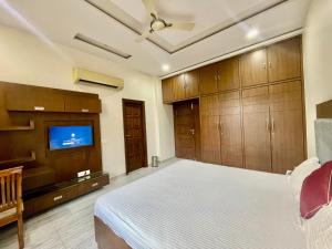 a bedroom with a bed and a flat screen tv at ZenRoofs-3 BHK Bungalow in Jaipur