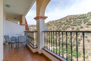 a balcony with a table and chairs and a mountain at Apartment Mountain View Torrox town in Torrox