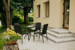 a patio with chairs and a table and a vase with flowers at Marsas 2 in Zarasai