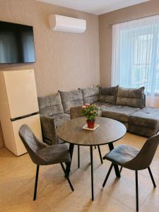 a living room with a couch and a table and chairs at Marsas 2 in Zarasai