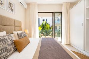 a bedroom with a bed and a large window at PARATY Apartment l Complex Ocean Terraces in Poste Lafayette